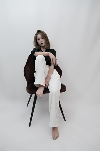 A fashionable woman sitting in a chair facing the camera