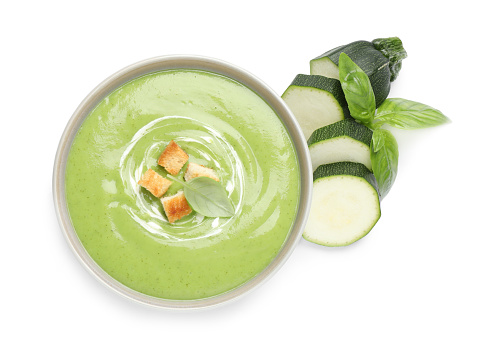Tasty homemade zucchini cream soup isolated on white, top view