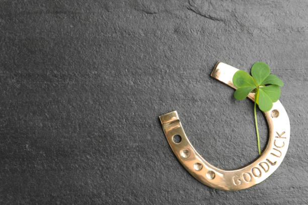 istock Clover leaf and horseshoe on grey stone table, flat lay with space for text. St. Patrick's Day celebration 1347029748