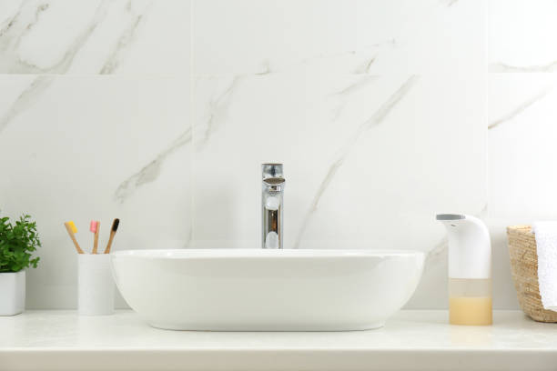 istock Modern automatic soap dispenser near sink in bathroom 1347030151