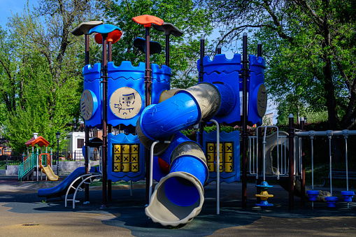 Colourful children playground with mixed plastic and metallic toys and materials in a sunny summer day in Floreasca Park in Bucharest, Romania