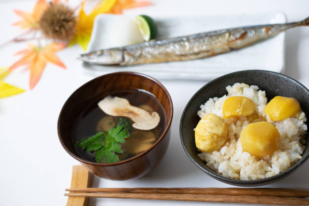 Seasonal Japanese tasty food of fall on a table Seasonal Japanese tasty food of fall, matsutake mushroom soup, chestnut rice, and salt-grilled saury on a table. matsutake mushroom stock pictures, royalty-free photos & images