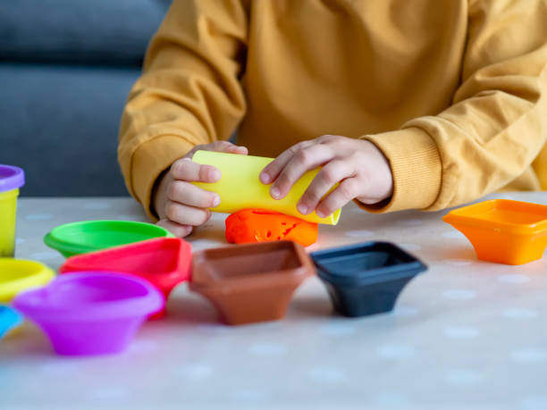 istock Child hands playing with orange plasticine, a modeling dough 1347031263