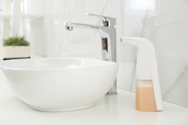 istock Modern automatic soap dispenser near sink in bathroom, closeup 1347031368