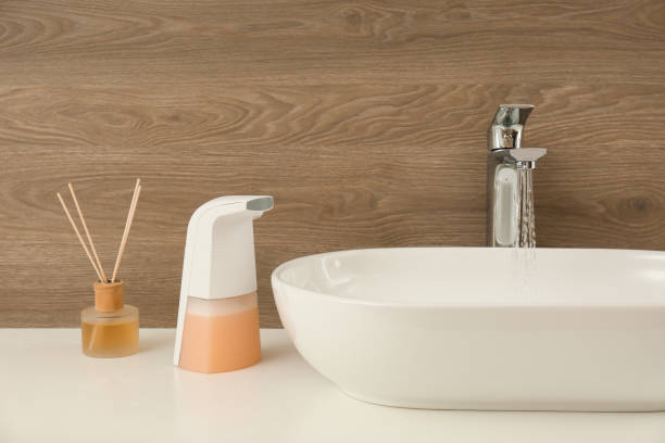 istock Modern automatic soap dispenser near sink in bathroom 1347031570