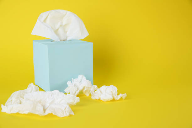 istock Used paper tissues and box on yellow background. Space for text 1347031618