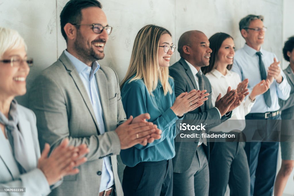 Business people applauding Group of people standing in a row and applauding Award Stock Photo