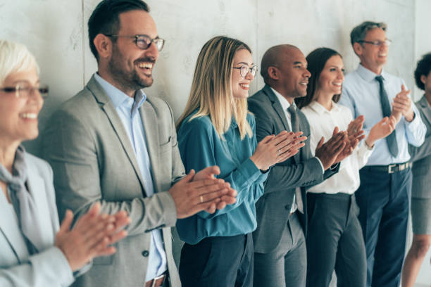 Business people applauding Group of people standing in a row and applauding organized group stock pictures, royalty-free photos & images