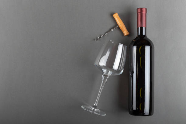 灰色の背景にコルク赤ワインボトル、コルクスクリューと空のワイングラス。アルコール飲料。ワイン造りのコンセプト。テキストのスペース。 - corked ストックフォトと画像