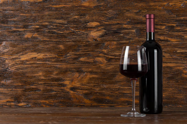 istock Wine bottle and glass on a wooden background. Space for text. 1347033408