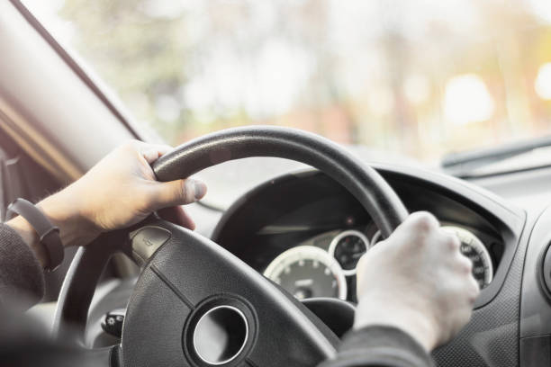 istock Man holding steering wheel and driving his car 1347034760