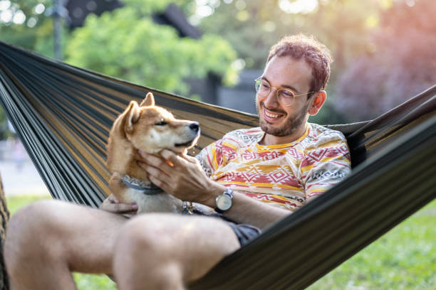 istock Man relaxing with his dog in the hammock 1347036322