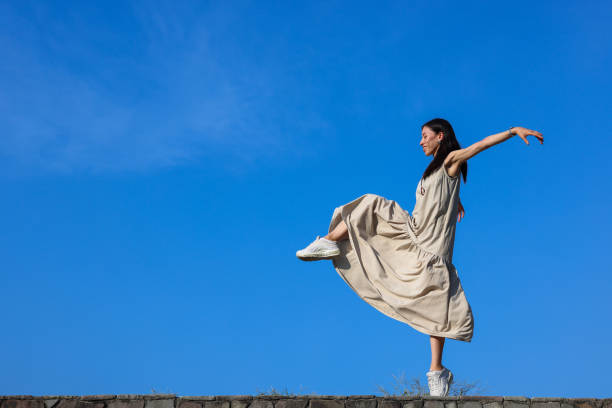 istock Beautiful woman dancing against sky on beach 1347039709