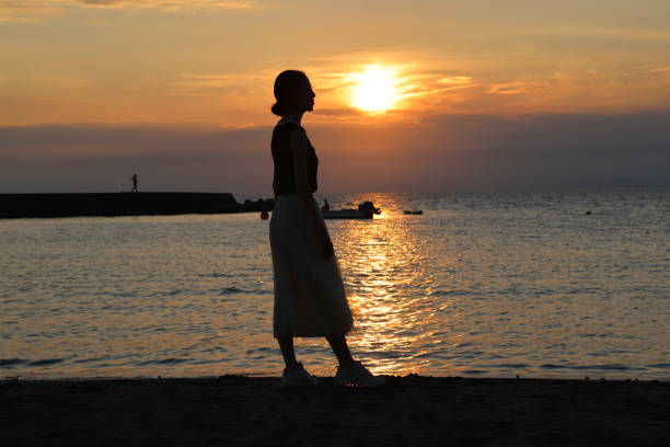 istock Beautiful woman relaxing on beach during Sunset 1347040040
