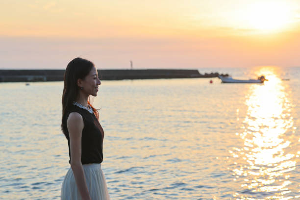 istock Beautiful woman relaxing on beach during sunset 1347040649