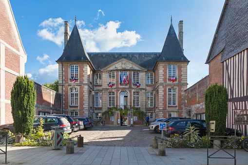 In this captivating photograph, the town hall of Quimper emerges as a beacon of architectural elegance when viewed from the Odet River flowing through the heart of the city. The town hall, a stately structure with a harmonious blend of historic and contemporary design elements, stands proudly on the riverbank, commanding attention against the scenic backdrop.\n\nThe river, reflecting the charm of the town hall in its tranquil waters, adds a touch of natural grace to the composition. The stone embankments and riverside promenade frame the building, creating a picturesque scene that seamlessly integrates urban and natural elements.\n\nAs the Odet River gracefully winds its way past the town hall, the architectural details come into focus—the intricate façade, the clock tower, and the embellishments that speak to the rich history of Quimper. The play of light on the building's surface adds a warm glow, accentuating the texture of the stonework and enhancing the visual appeal of this iconic municipal landmark.\n\nThis image captures a moment where architecture and nature converge, inviting viewers to appreciate the town hall's significance within the charming setting of Quimper's riverfront.