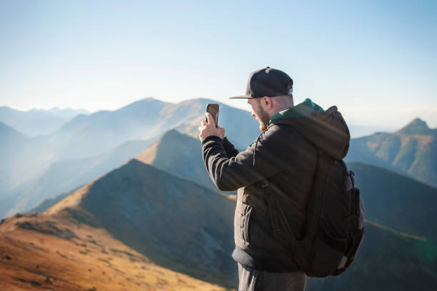 istock Tourist takes on smartphone mountain scenery 1347042952
