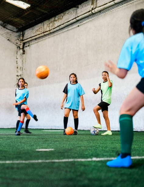 istock Girls practicing soccer at indoor field 1347043870