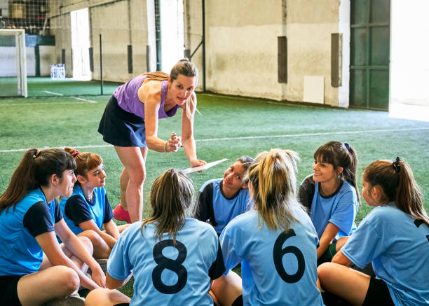 istock Coach discussing game plan with girls soccer team 1347043972