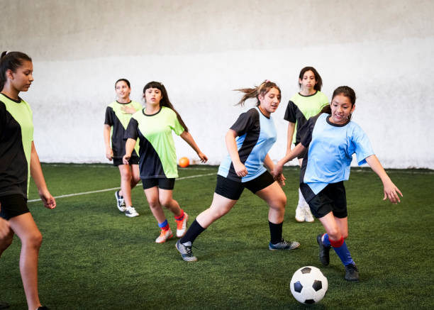 屋内コートでサッカーの試合をする女子選手 - futsal indoors soccer ball soccer ストックフォトと画像