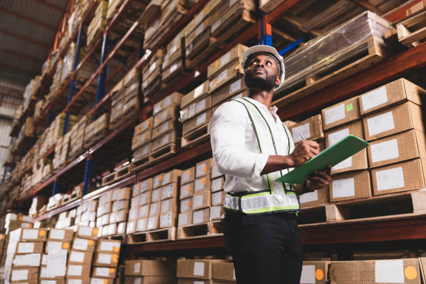 Black male staff working checking stock in logistic warehouse stock photo