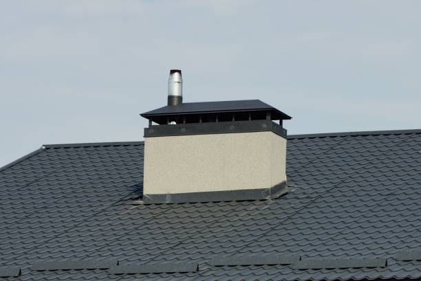 istock one large white concrete chimney on a black tiled roof 1347048393