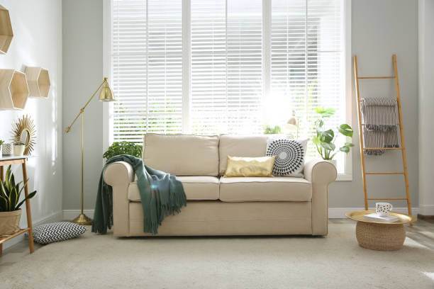 istock Stylish beige sofa in modern living room interior 1347049761
