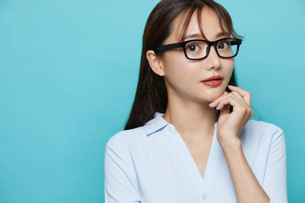 portrait d’affaires d’une jeune femme asiatique sur fond bleu - beautiful office people shock photos et images de collection