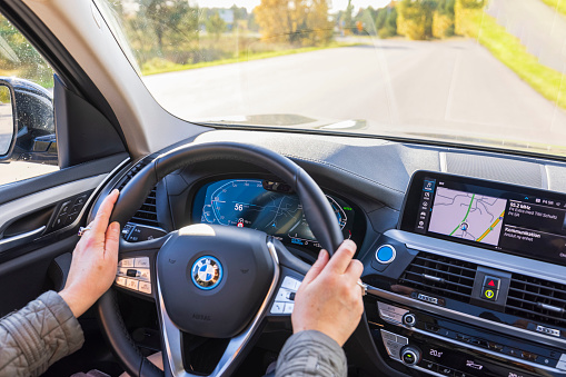 Sweden. Uppsala. 10.17.2021. Close up view of female hands on steering wheel of electric car BMW iX3.