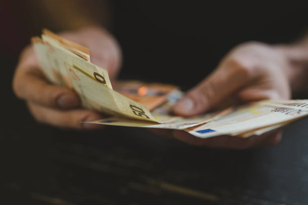 hombre de negocios contando dinero. manos masculinas ricas sostiene y cuenta billetes en efectivo de billetes de 50 euros o billetes de moneda - human hand beak currency stack fotografías e imágenes de stock