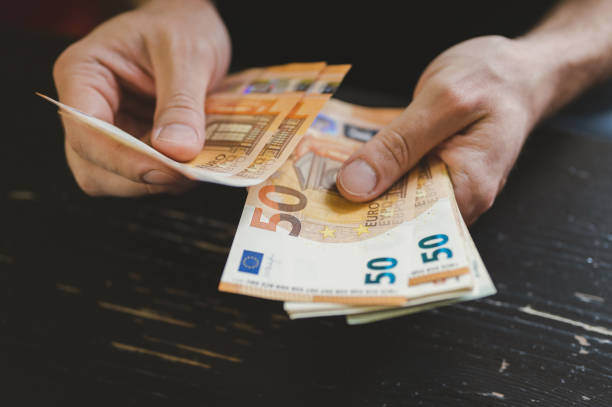 hombre de negocios contando dinero. manos masculinas ricas sostiene y cuenta billetes en efectivo de billetes de 50 euros o billetes de moneda - human hand beak currency stack fotografías e imágenes de stock