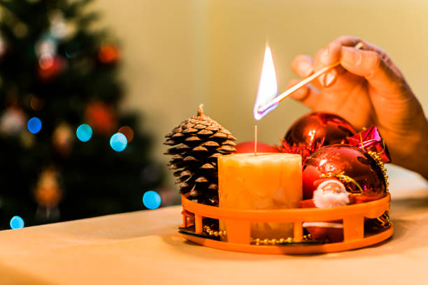 istock Woman's hand lighting a Christmas candle. 1347055457
