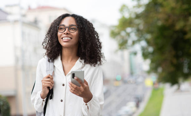 istock Happy woman using smart phone in a city 1347055582