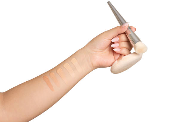 Female hand holding brush and cosmetic puff