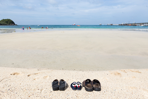 Family leave there shoes on the beach, women shoes, baby shoes and men shoes