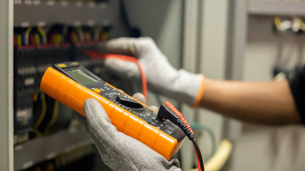 istock Electrician engineer uses a multimeter to test the electrical installation and power line current in an electrical system control cabinet. 1347059273