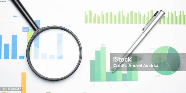 Single Magnifying Glass With Black Handle Leaning On The Financial Data Concept Of Business And Finance Research Stock Photo - Download Image Now