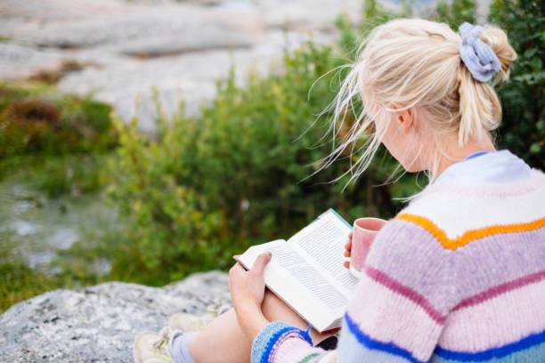 istock Woman reading her book outside in nature 1347060674
