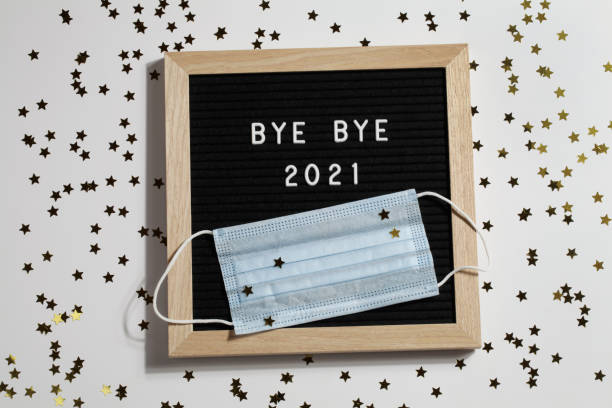 istock black letter board with text BYE BYE 2021 with small stars and mask on white background. Happy new ear 2022 concept. 1347062304