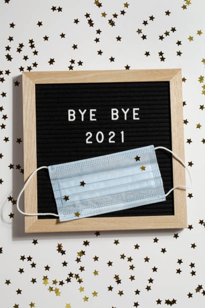 istock black letter board with text BYE BYE 2021 with small stars and mask on white background. Happy new ear 2022 concept. 1347062305