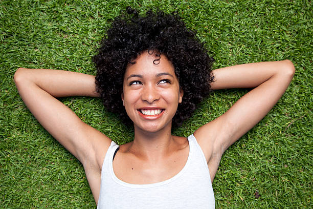 istock Smiling woman lying on grass 134706315