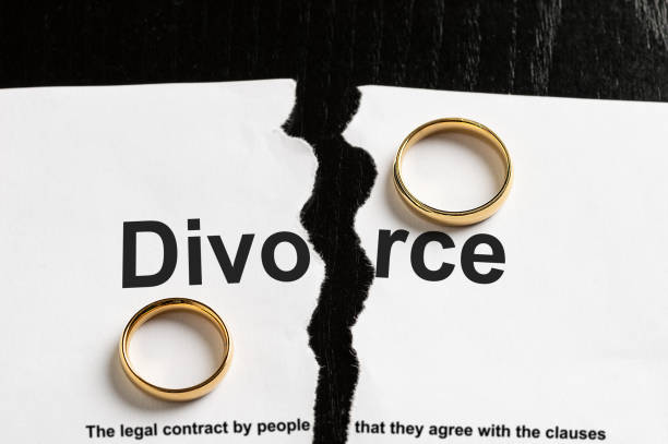 divorce concept Closeup of a break document with the word divorce and two wedding rings pictures of divorce papers stock pictures, royalty-free photos & images