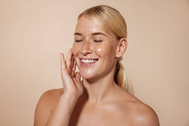 istock Happy woman with blond hair touching face in studio 1347067232