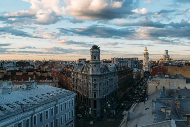 Photo of Cityscape of Neoclassicism residential house with tower on Five Corners square in St Petersburg, Russia. Cloudy sunset sky.