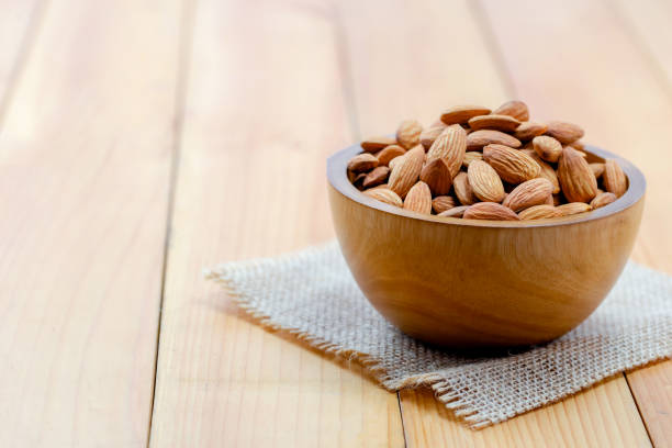 istock Almonds in brown bowl on wooden background 1347072908