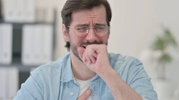 istock Portrait of Sick Young Man Coughing 1347073557