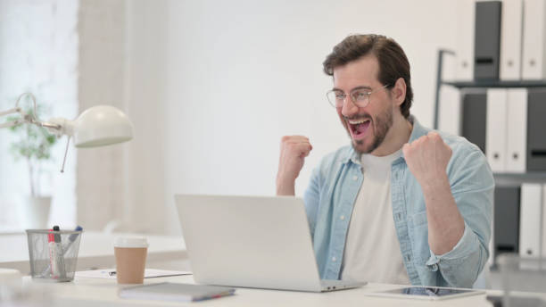 istock Successful Young Man Celebrating on Laptop at Work 1347075974