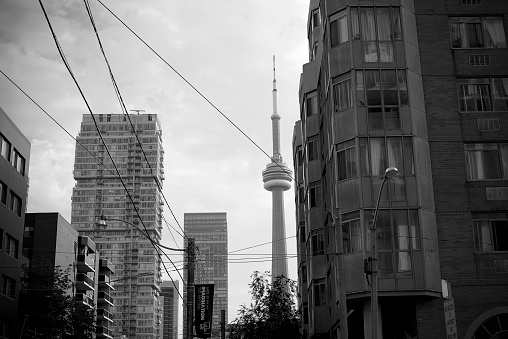 Toronto: Ontario, Canada- October, 14 2021: Th CN Tower peaking from behind the building.