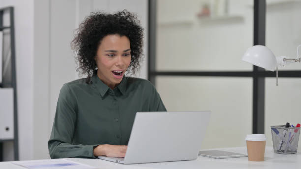 istock Successful African Woman Celebrating on Laptop 1347077513