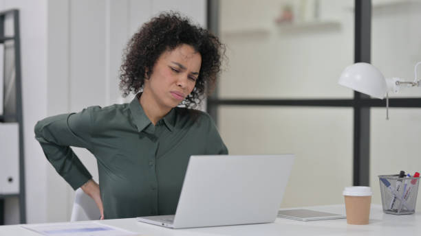 istock African Woman having Back Pain while using Laptop 1347077771